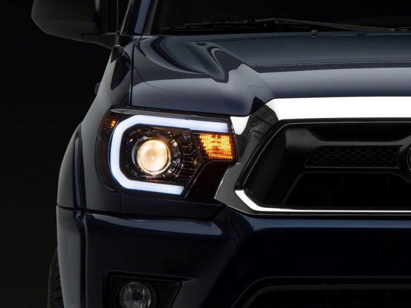Raxiom 12-15 Toyota Tacoma Axial Projector Headlights w/ SEQL LED Bar- Blk Housing (Clear Lens) - TT21850