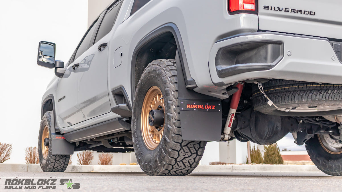 Rear angle of Chevrolet Silverado 2500/3500 HD equipped with Rokblokz Step-Back Mud Flap Kit, designed for off-road durability.